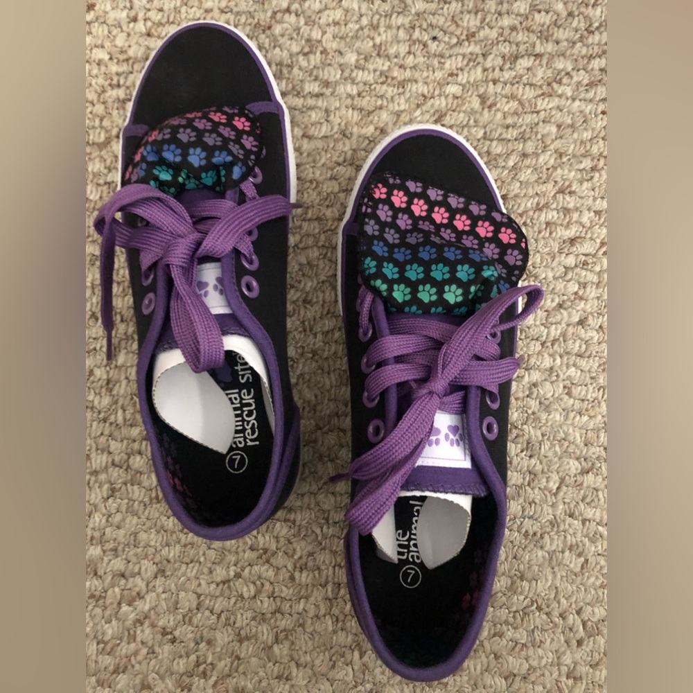 NWT black sneaker sz 7 w/ multi colored paw prints on flap. Purple shoe laces